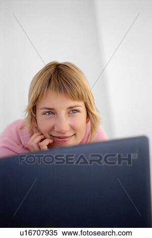Smiling woman sitting at laptop View Large Photo Image Stock Photography - Smiling woman sitting at laptop. Fotosearch