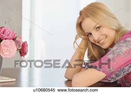 Smiling woman sitting at table View Large Photo Image Stock Photography - Smiling woman sitting at table. Fotosearch