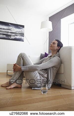 Smiling woman sitting by couch View Large Photo Image Stock Photograph - Smiling woman sitting by couch. Fotosearch