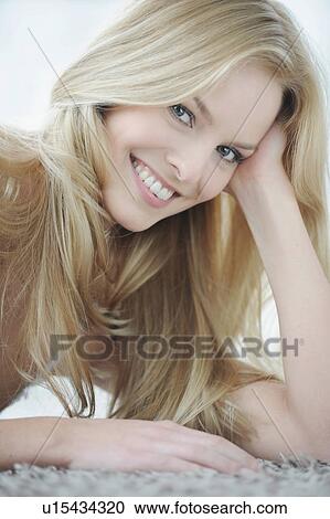 Stock Image - Smiling woman sitting indoors. Fotosearch