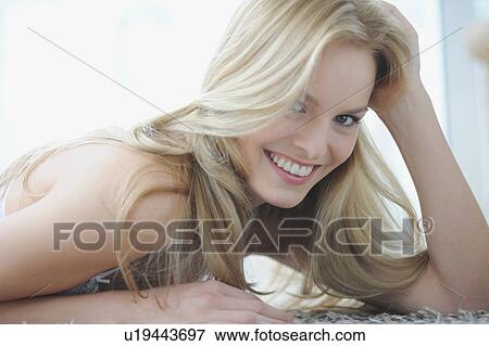 Stock Photo - Smiling woman sitting indoors. Fotosearch