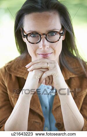 Smiling woman wearing eyeglasses View Large Photo Image Stock Image - Smiling woman wearing eyeglasses. Fotosearch