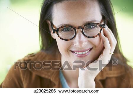 Smiling woman wearing eyeglasses View Large Photo Image Stock Photograph - Smiling woman wearing eyeglasses. Fotosearch