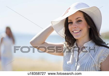 Stock Photo - Smiling woman wearing sunhat. Fotosearch
