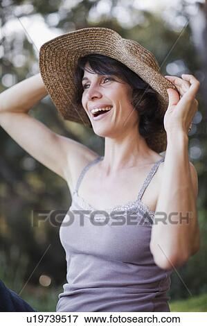 Smiling woman wearing sunhat View Large Photo Image Stock Photo - Smiling woman wearing sunhat. Fotosearch