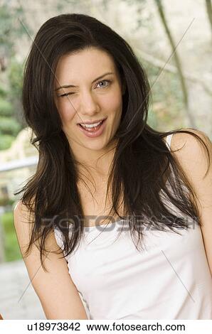 Stock Image - Smiling woman winking. Fotosearch