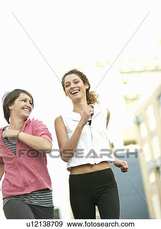 Stock Photo - Smiling women jogging together. Fotosearch
