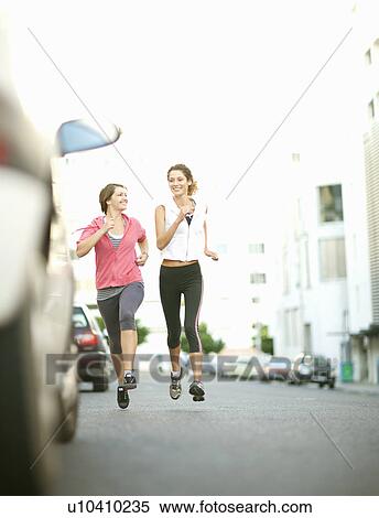 Smiling women jogging together View Large Photo Image Stock Photography - Smiling women jogging together. Fotosearch