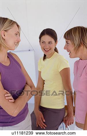 Stock Photo - Smiling women talking in office. Fotosearch