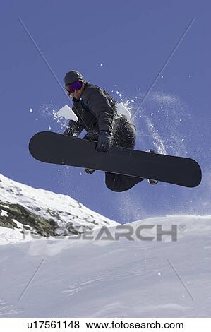 Snowboarder doing tricks on slope View Large Photo Image Stock Photo - Snowboarder doing tricks on slope. Fotosearch