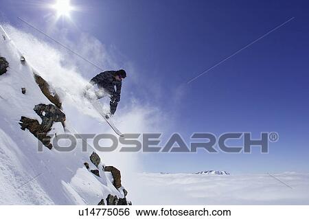 Stock Photograph - Snowboarder doing tricks on slope. Fotosearch