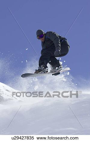 Snowboarder doing tricks on slope View Large Photo Image Stock Photography - Snowboarder doing tricks on slope. Fotosearch