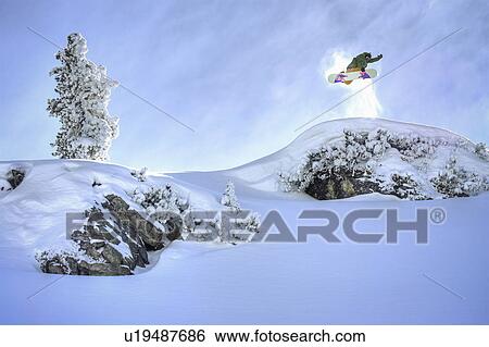 Snowboarder jumping from hillside View Large Photo Image Stock Photograph - Snowboarder jumping from hillside. Fotosearch