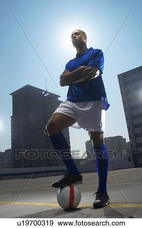 Stock Photo - Soccer player with ball on rooftop. Fotosearch