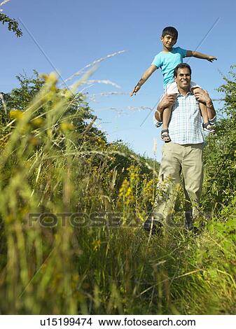 Son sitting on father’s shoulders View Large Photo Image Picture - Son sitting on father’s shoulders. Fotosearch