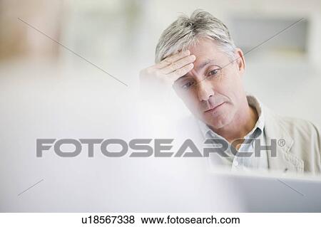 Stressed businessman working in office View Large Photo Image Stock Photo - Stressed businessman working in office. Fotosearch