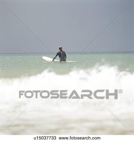 Surfer walking in ocean View Large Photo Image Stock Image - Surfer walking in ocean. Fotosearch