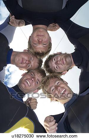 Surfers putting heads together on beach View Large Photo Image Stock Image - Surfers putting heads together on beach. Fotosearch