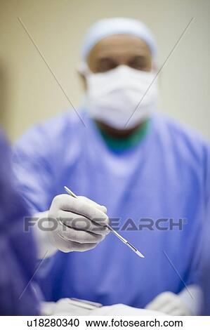 Stock Image - Surgeon holding scalpel. Fotosearch