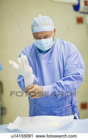 Surgeon pulling on latex gloves View Large Photo Image Stock Image - Surgeon pulling on latex gloves. Fotosearch