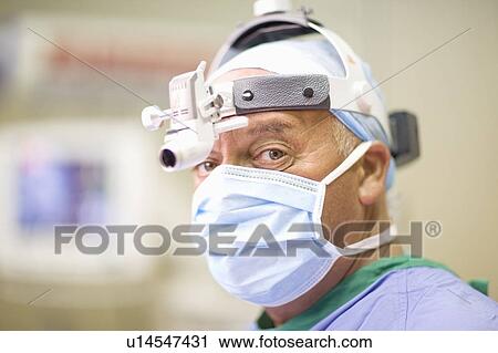 Surgeon wearing mask and headlamp View Large Photo Image Stock Image - Surgeon wearing mask and headlamp. Fotosearch