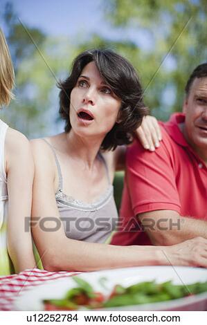 Surprised woman sitting at picnic table View Large Photo Image Picture - Surprised woman sitting at picnic table. Fotosearch