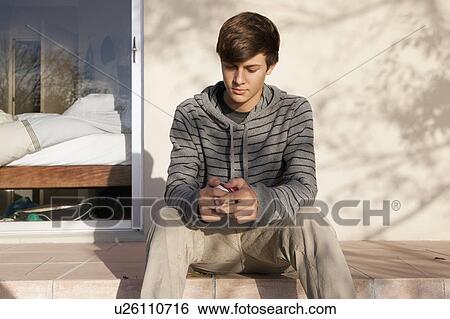 Teenage boy examining ball outdoors View Large Photo Image Stock Photograph - Teenage boy examining ball outdoors. Fotosearch