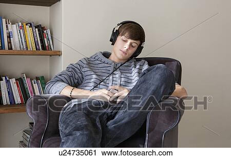 Stock Image - Teenage boy listening to headphones. Fotosearch