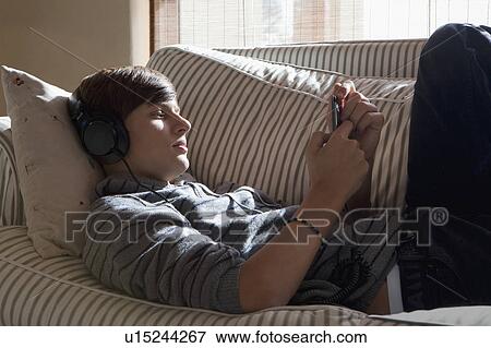 Stock Photo - Teenage boy listening to headphones. Fotosearch