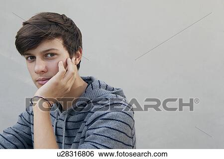 Teenage boy resting chin in hand View Large Photo Image Stock Photograph - Teenage boy resting chin in hand. Fotosearch