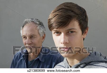 Teenage boy sitting with father View Large Photo Image Stock Photo - Teenage boy sitting with father. Fotosearch