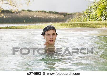 Stock Image - Teenage boy swimming in lake. Fotosearch