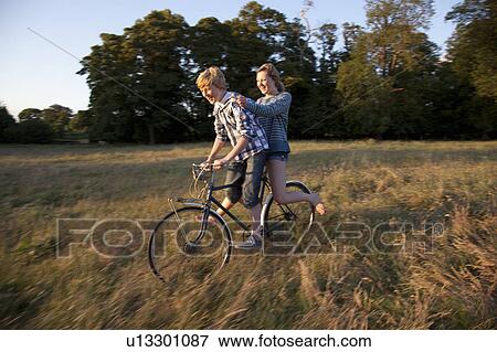 Stock Photo - Teenage couple riding bicycle together. Fotosearch
