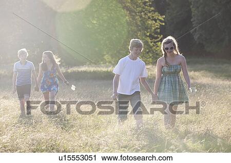 Teenage couples walking in field View Large Photo Image Stock Image - Teenage couples walking in field. Fotosearch