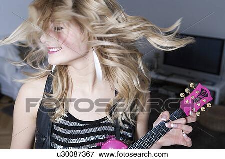 Teenage girl holding miniature guitar View Large Photo Image Stock Photo - Teenage girl holding miniature guitar. Fotosearch
