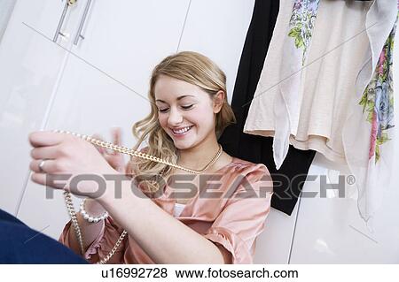 Teenage girl trying on necklace View Large Photo Image Stock Photo - Teenage girl trying on necklace. Fotosearch