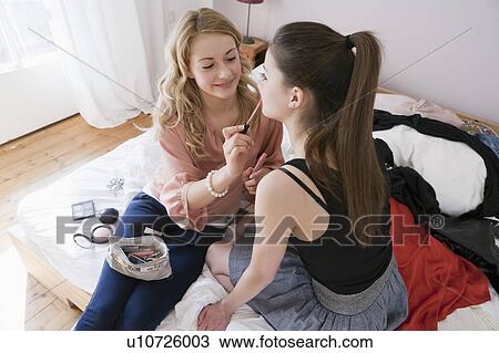 Stock Image - Teenage girls applying makeup. Fotosearch