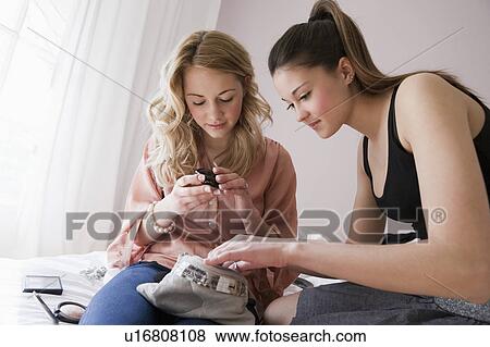 Teenage girls going through makeup View Large Photo Image Stock Photo - Teenage girls going through makeup. Fotosearch