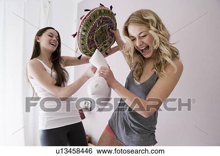 Teenage girls having pillow fight View Large Photo Image Stock Photograph - Teenage girls having pillow fight. Fotosearch