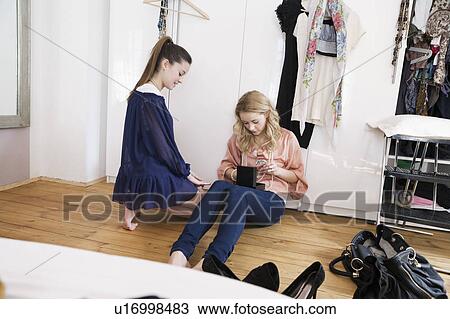 Stock Image - Teenage girls sitting in bedroom. Fotosearch