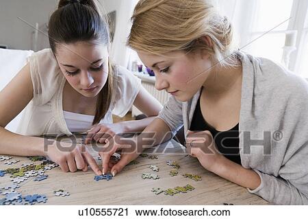 Teenage girls working on jigsaw puzzle View Large Photo Image Stock Image - Teenage girls working on jigsaw puzzle. Fotosearch