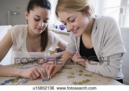 Teenage girls working on jigsaw puzzle View Large Photo Image Stock Photograph - Teenage girls working on jigsaw puzzle. Fotosearch