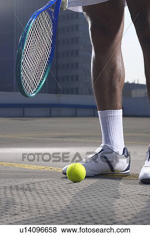 Tennis player with ball on rooftop court View Large Photo Image Stock Photo - Tennis player with ball on rooftop court. Fotosearch