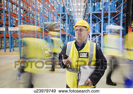 Stock Photo - Time lapse view of workers in warehouse. Fotosearch