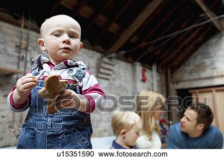 Toddler boy holding cookie in kitchen View Large Photo Image Stock Image - Toddler boy holding cookie in kitchen. Fotosearch