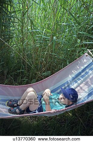 Toddler boy laying in hammock View Large Photo Image Stock Image - Toddler boy laying in hammock. Fotosearch