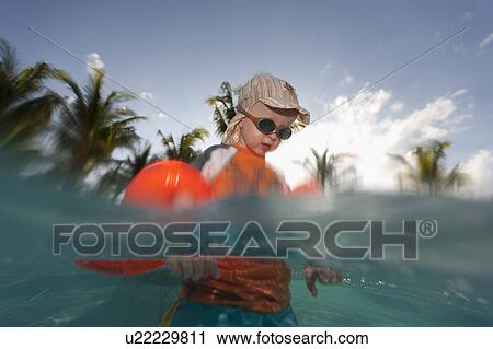 Toddler boy playing in water outdoors View Large Photo Image Stock Image - Toddler boy playing in water outdoors. Fotosearch