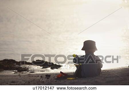 Toddler boy playing on beach View Large Photo Image Stock Photo - Toddler boy playing on beach. Fotosearch