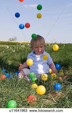 Stock Image - Toddler playing with colored balls. Fotosearch