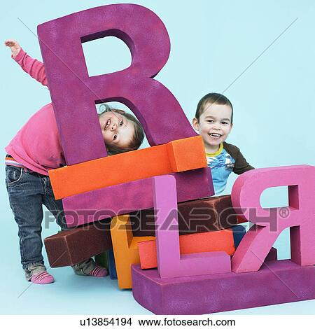 Picture - Toddlers playing with oversize letters. Fotosearch